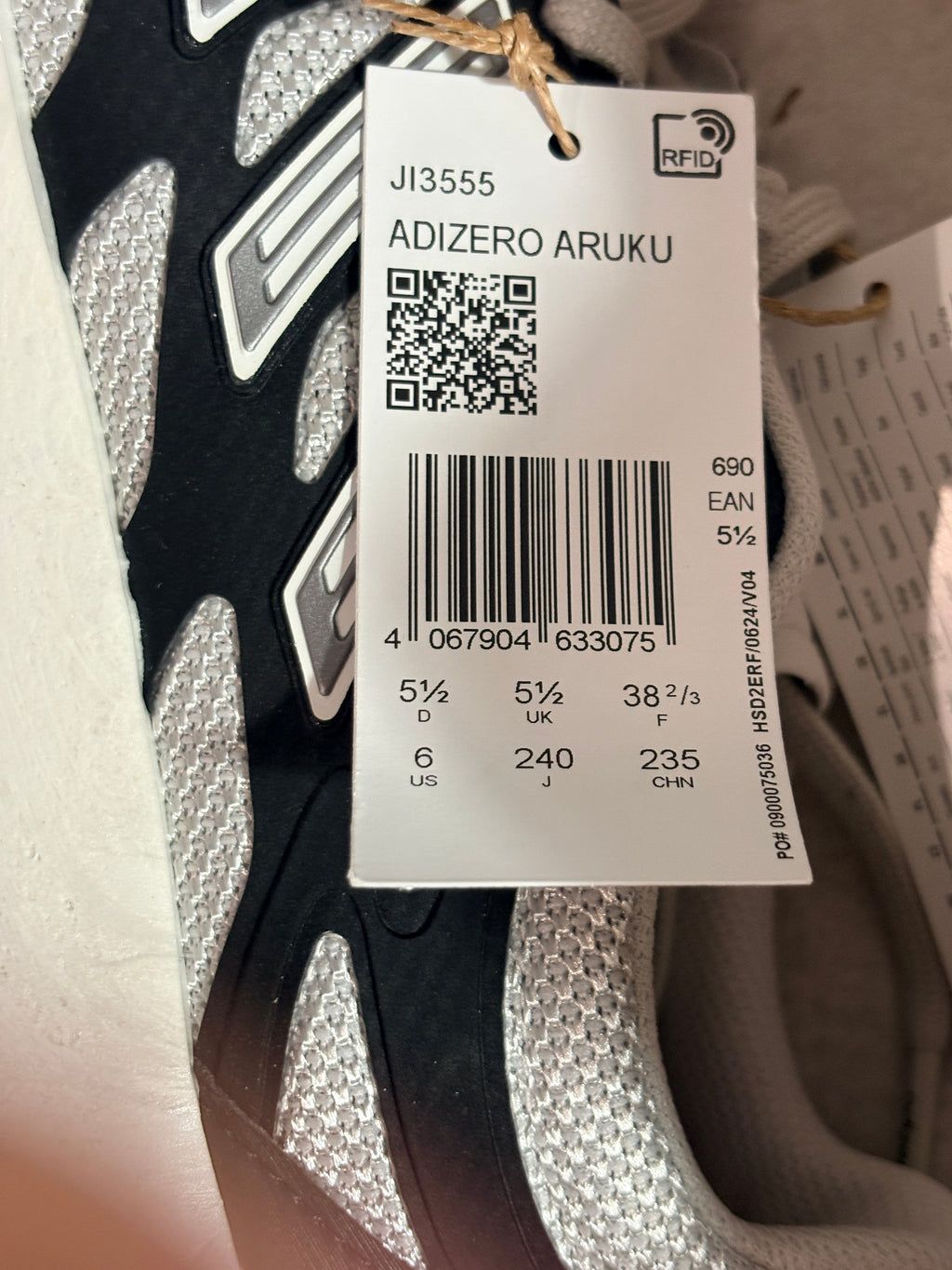 Etiquette de prix et informations de taille sur une basket FASHION SC Adidas Adizero Aruku noire et grise
