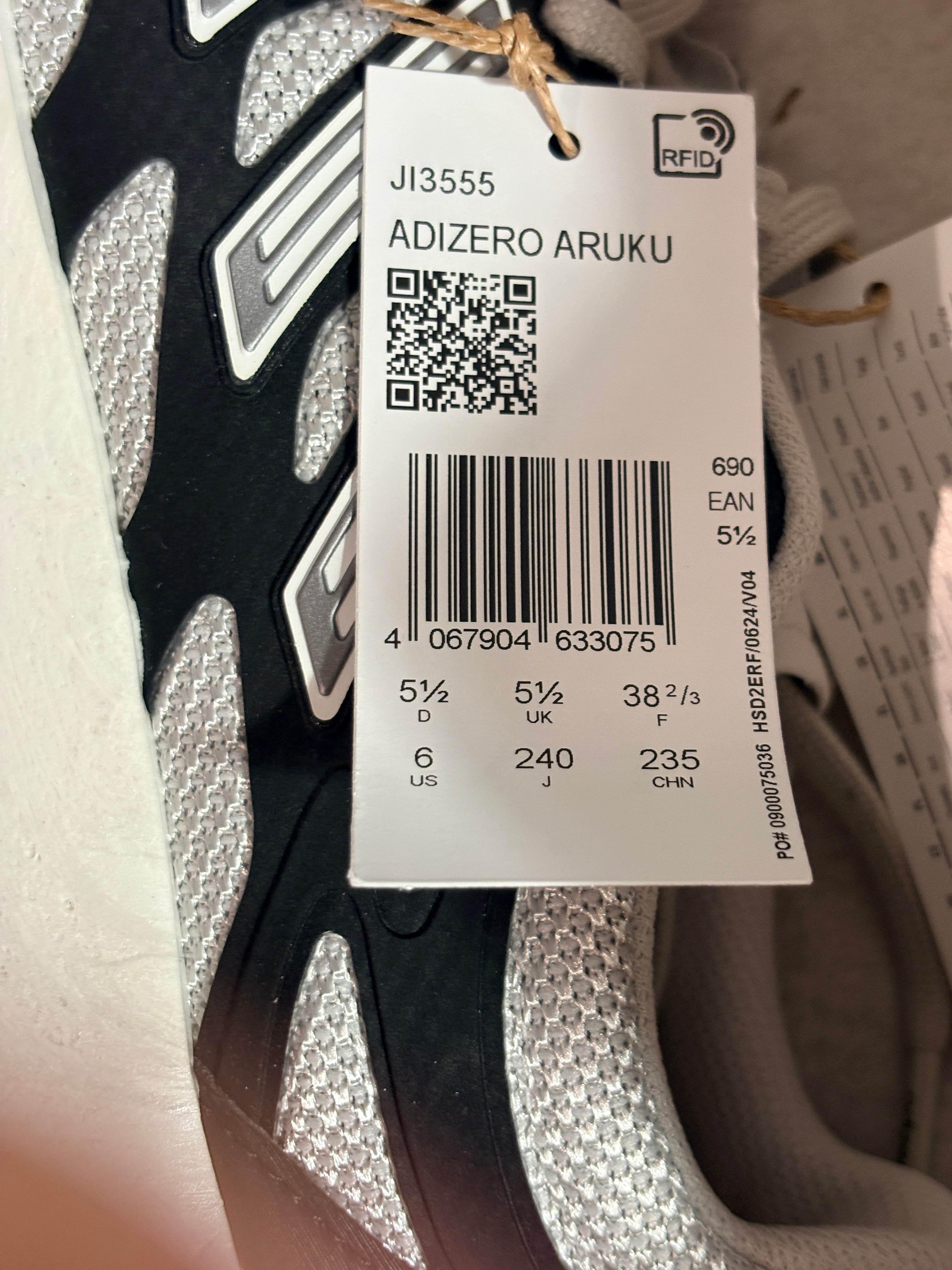 Etiquette de prix et informations de taille sur une basket FASHION SC Adidas Adizero Aruku noire et grise