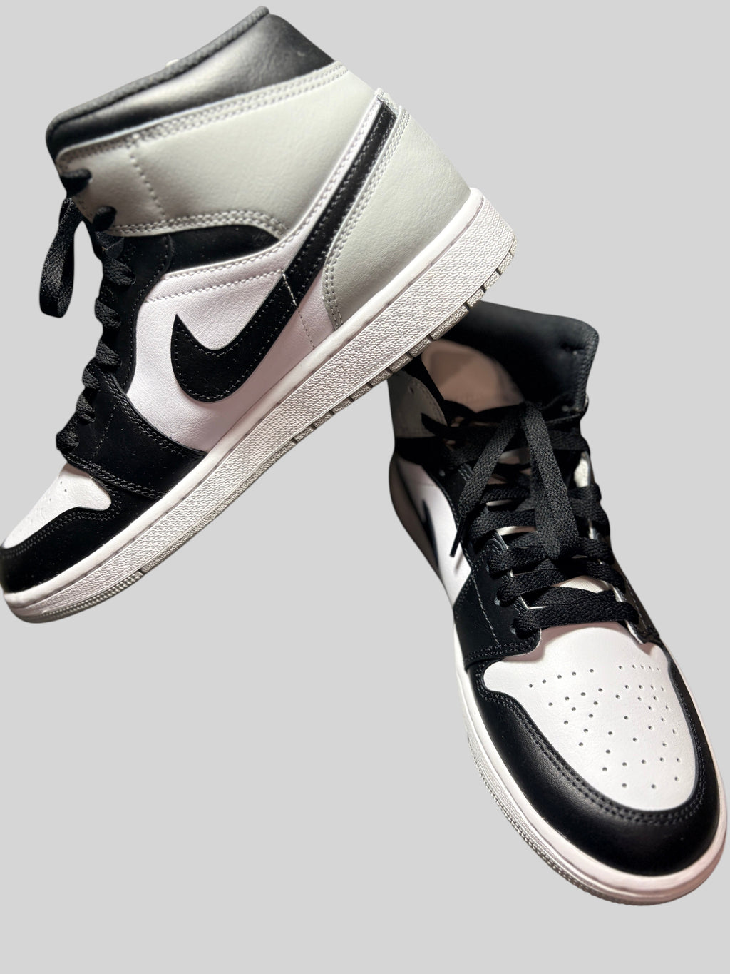 Baskets FASHION SC Air Jordan 1 Mid Barons en cuir blanc, noir et gris, design montant classique et lacets noirs.