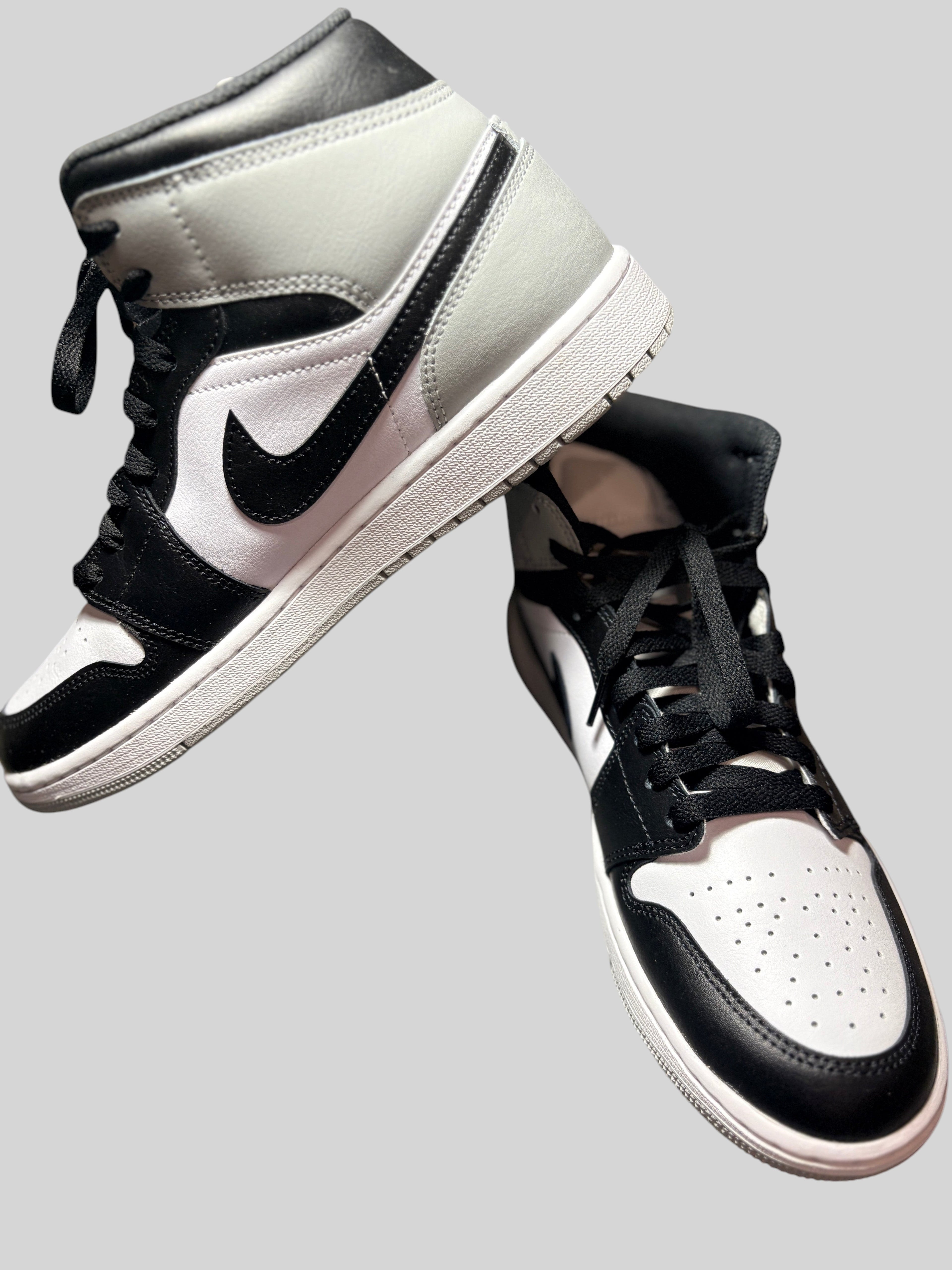 Baskets FASHION SC Air Jordan 1 Mid Barons en cuir blanc, noir et gris, design montant classique et lacets noirs.