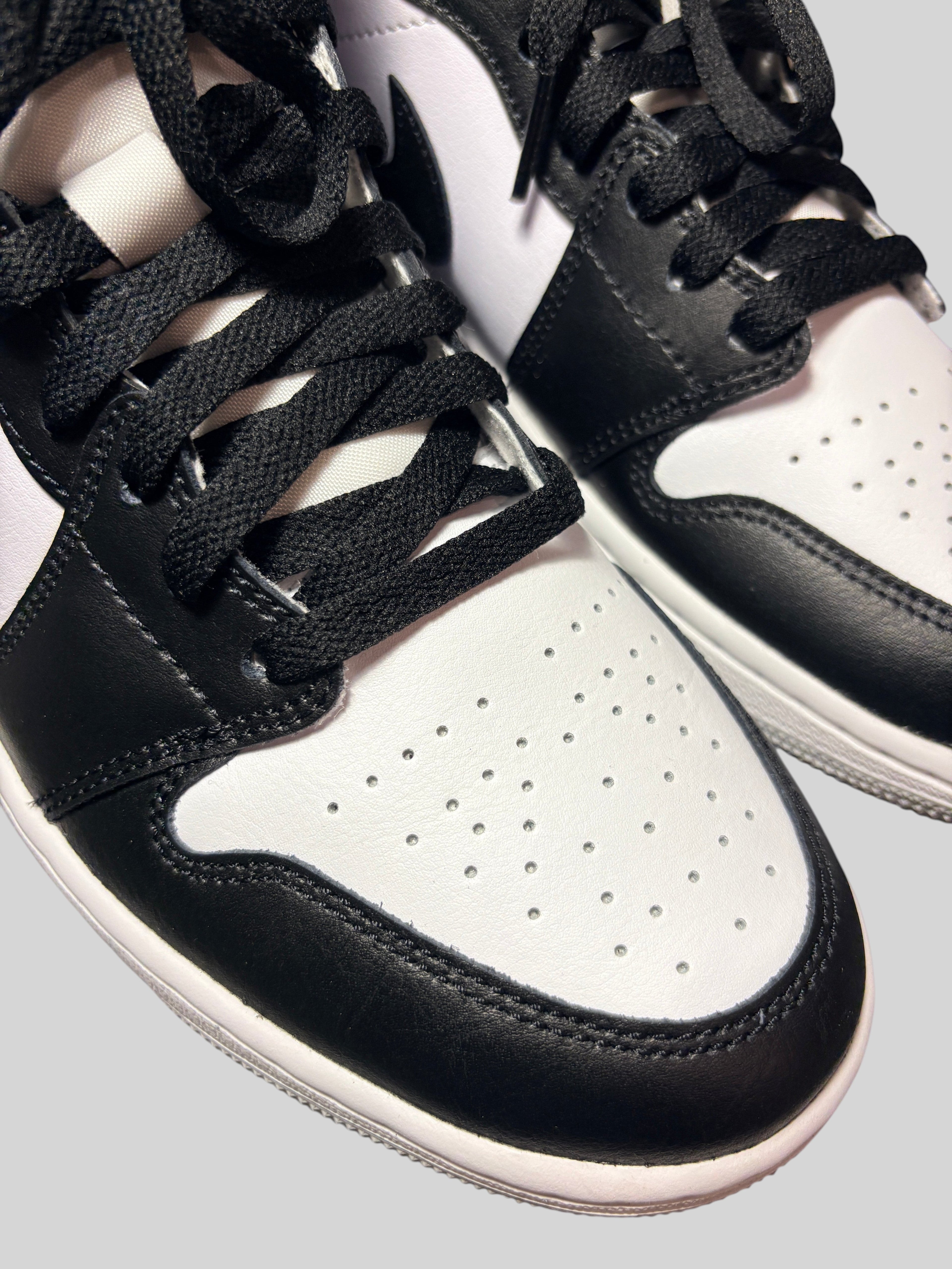 Baskets Air Jordan 1 Mid Barons FASHION SC en cuir blanc et noir avec lacets noirs, vue rapprochée sur l'avant.