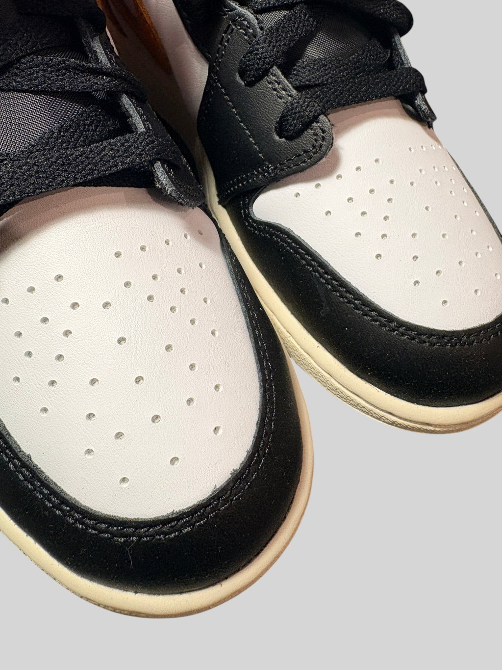 Bout avant des baskets FASHION SC Air Jordan 1 Mid GS Black Toe Starfish en cuir blanc et noir avec lacets noirs