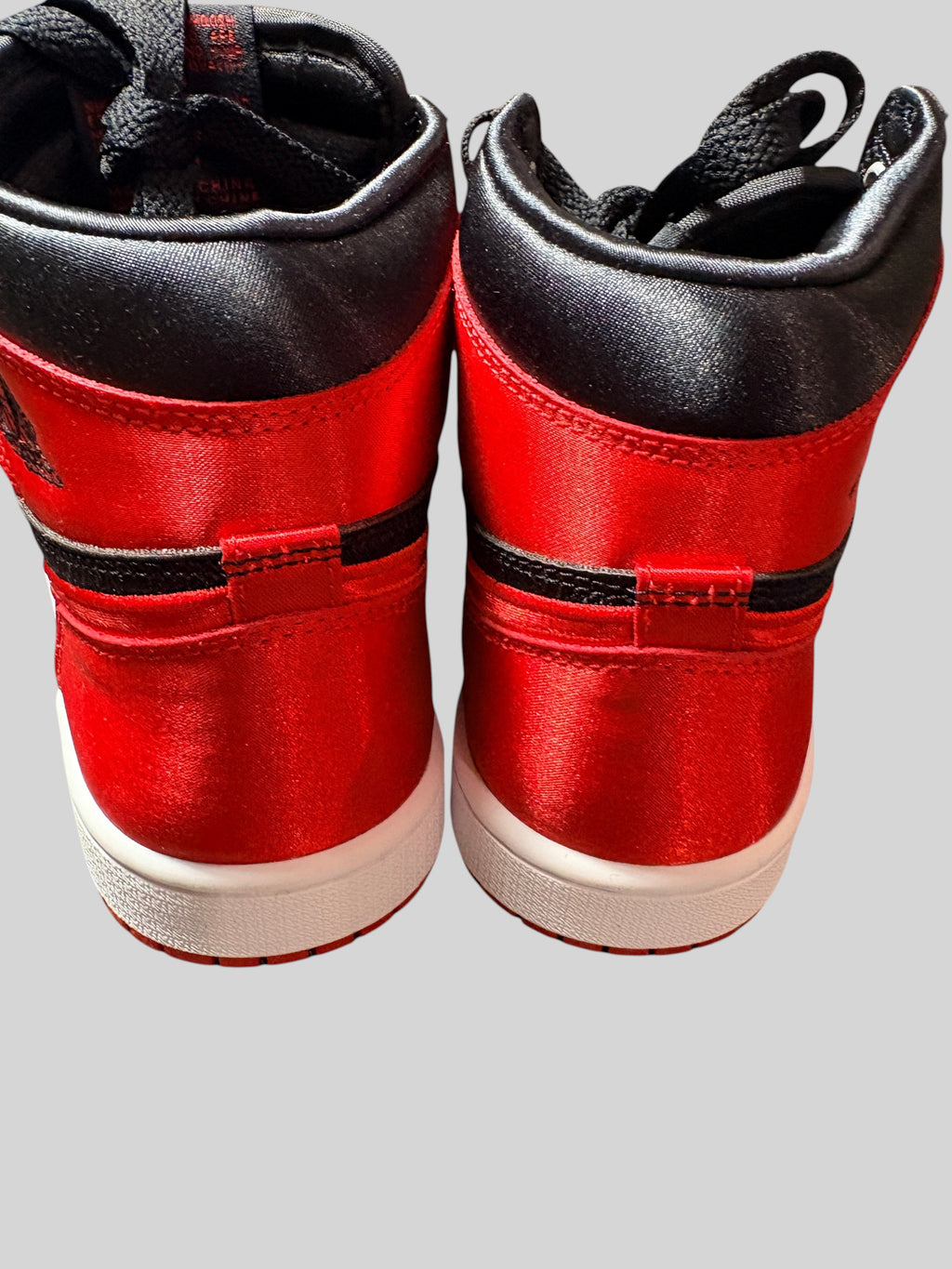 Vue arrière des baskets FASHION SC Air Jordan 1 High OG Satin Bred en satin rouge et noir avec semelle blanche