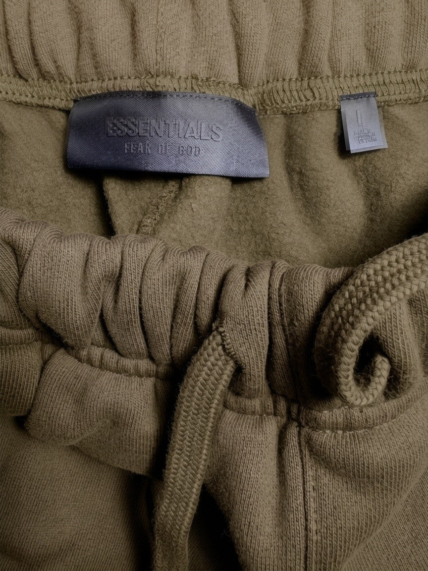 Détail de la taille élastiquée et étiquette FASHION SC Fear of God ESSENTIALS en molleton kaki Military
