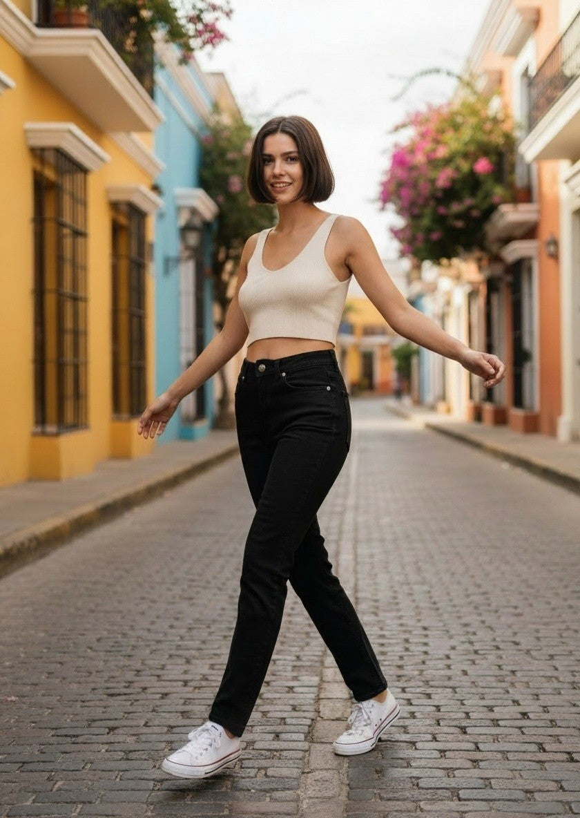 Modèle portant un jean droit noir GANNI en coton biologique dans une rue colorée, style décontracté avec crop top
