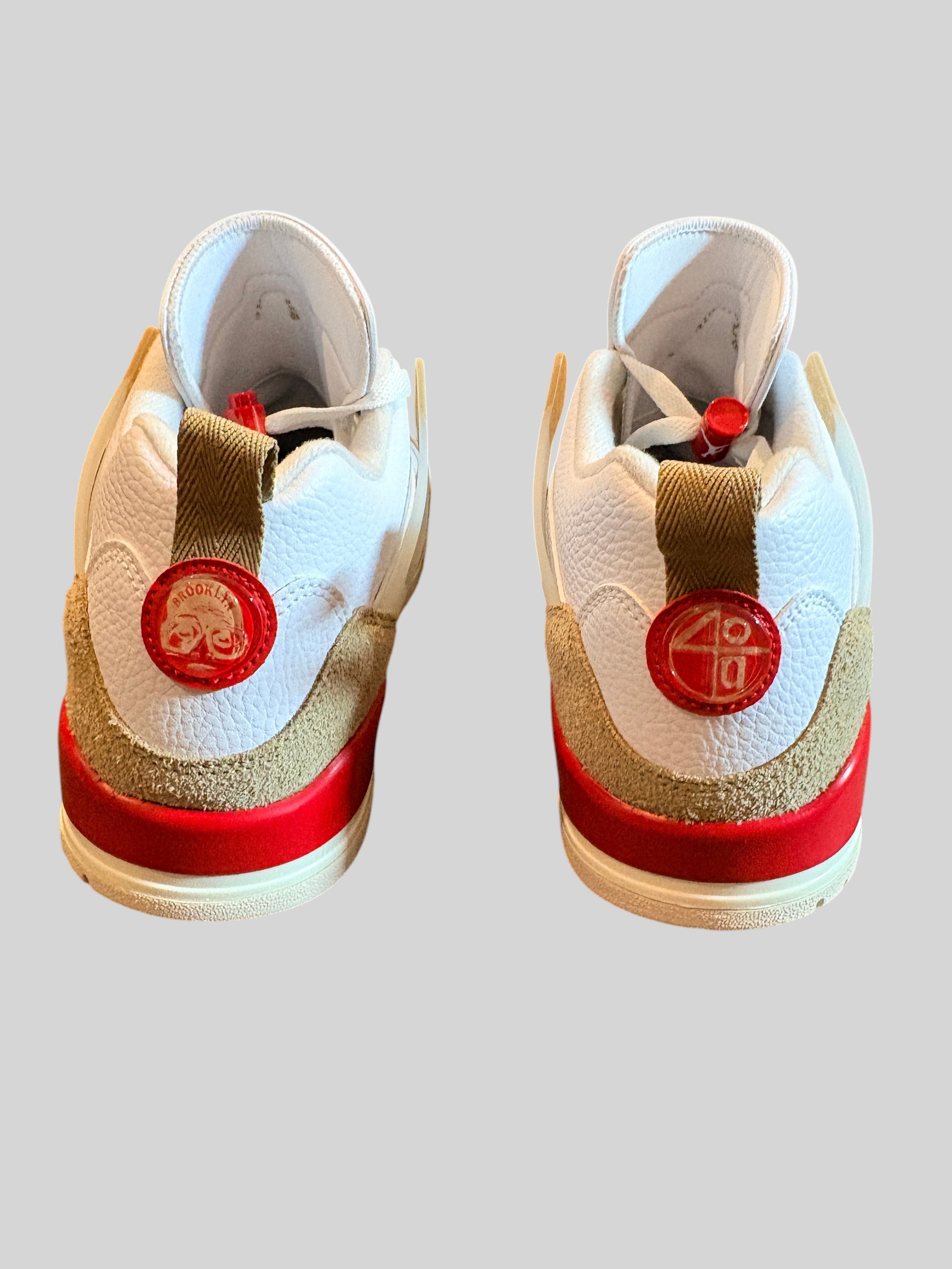 Vue arrière des baskets FASHION SC Jordan Spizike Low blanches avec détails camouflage, cuir texturé et accents rouges