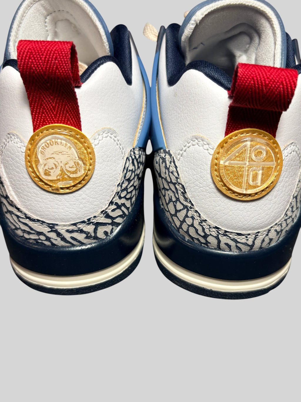Vue arrière des baskets FASHION SC Jordan Spizike Low avec détails en cuir blanc, imprimé éléphant et logos dorés.