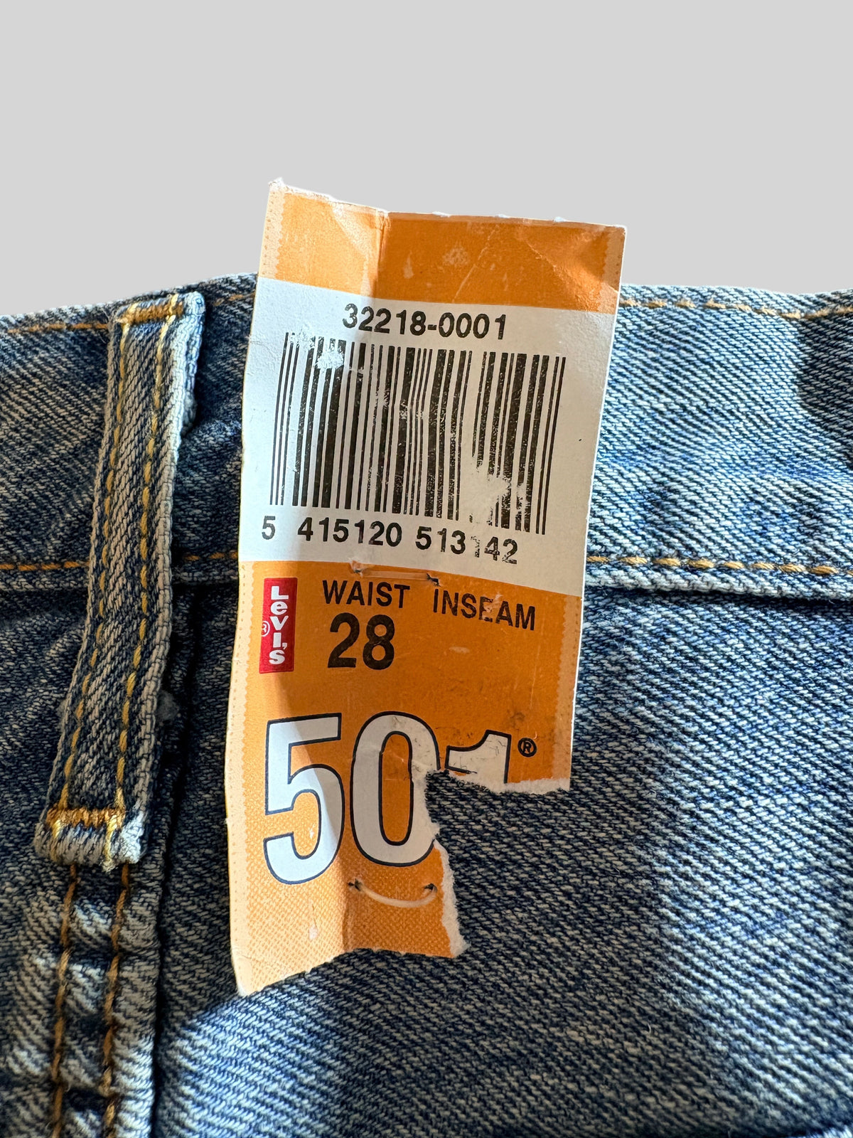 Étiquette de prix originale Levi’s 501 taille W28 sur un short en jean bleu délavé de la boutique FASHION SC