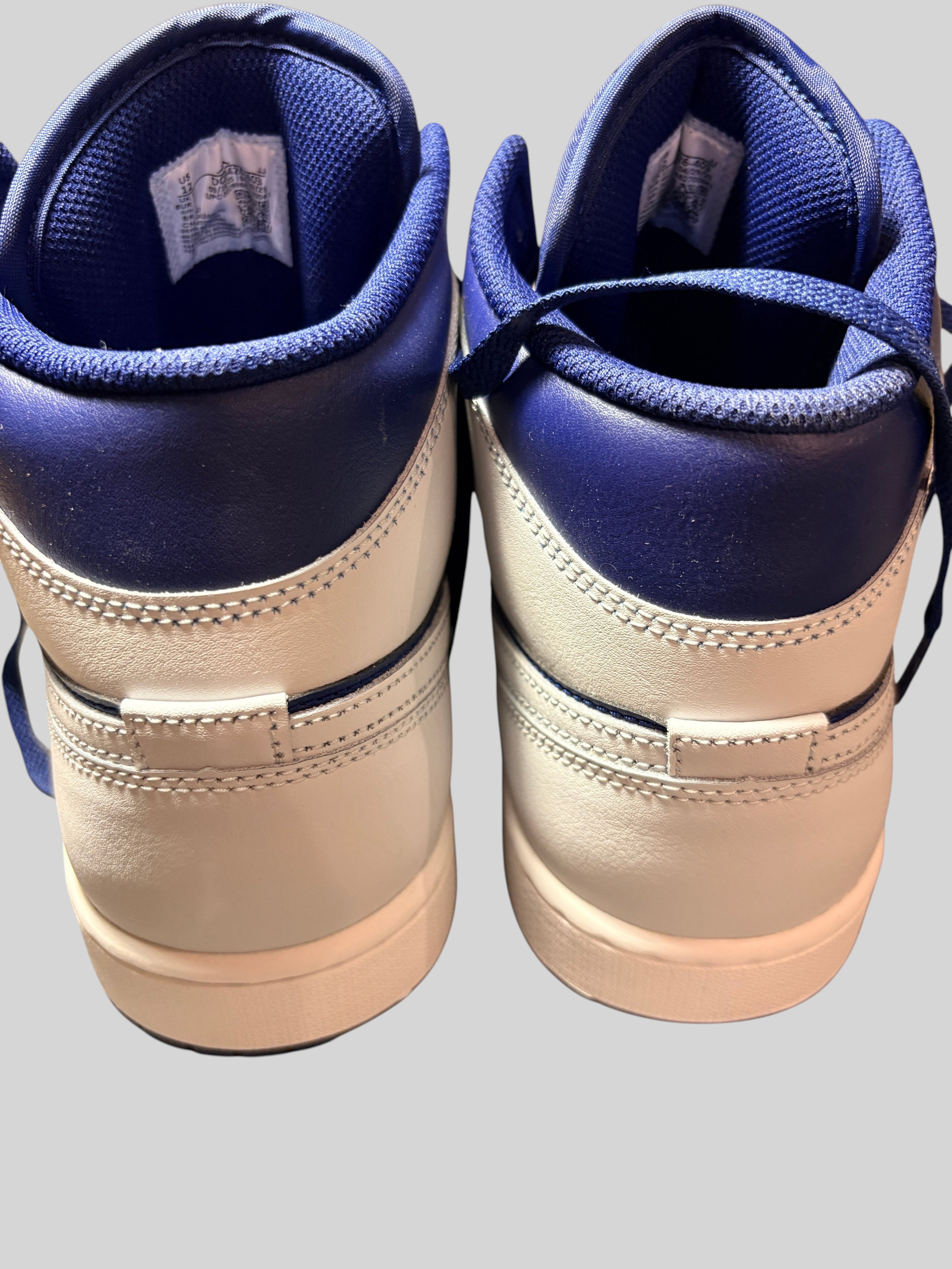 Vue arrière des baskets FASHION SC Nike Air Jordan 1 Mid Blue Void en cuir bleu et blanc avec détails texturés
