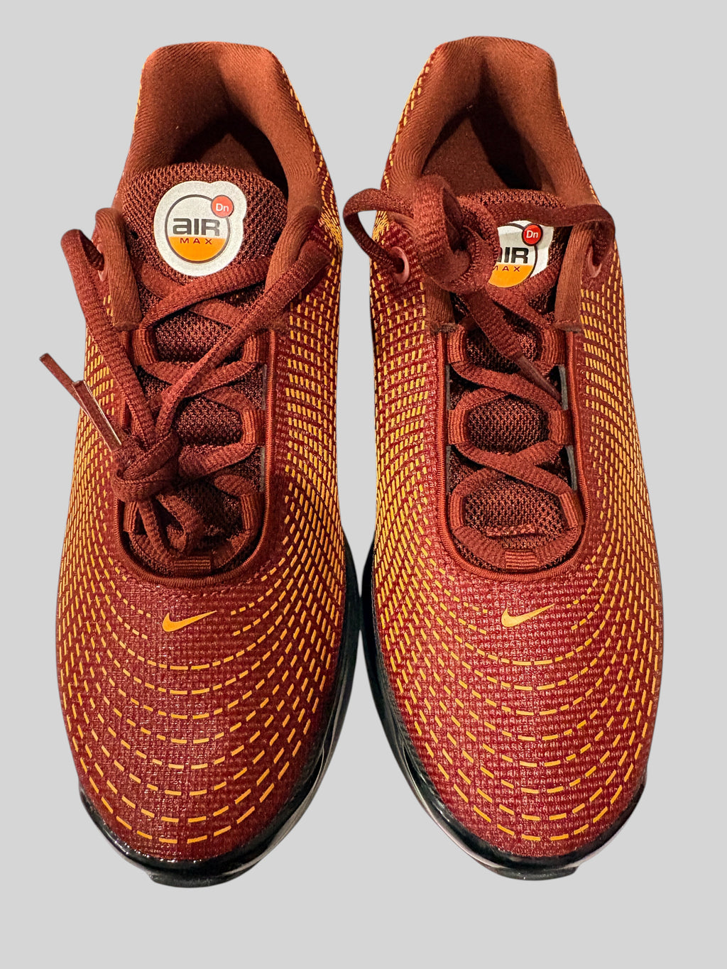 Baskets FASHION SC Nike Air Max Dn GS Dark Team Red en mesh texturé rouge foncé avec détails orange et logo Nike