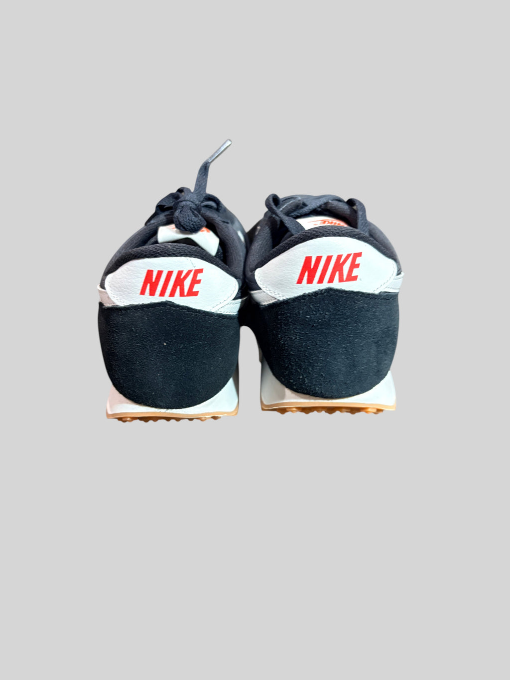Vue arrière des baskets FASHION SC Nike Daybreak noires et blanches avec logo rouge sur le talon