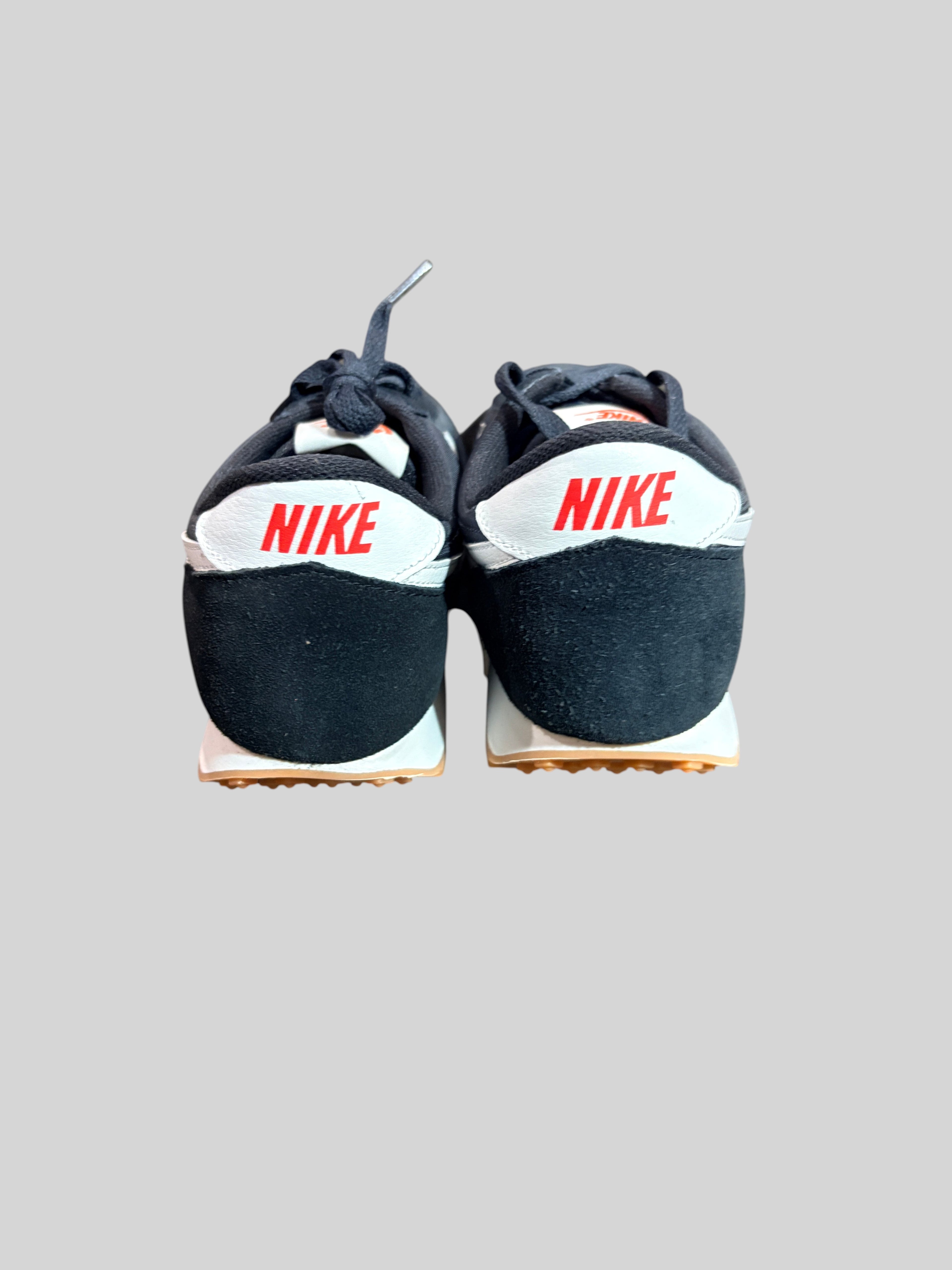 Vue arrière des baskets FASHION SC Nike Daybreak noires et blanches avec logo rouge sur le talon