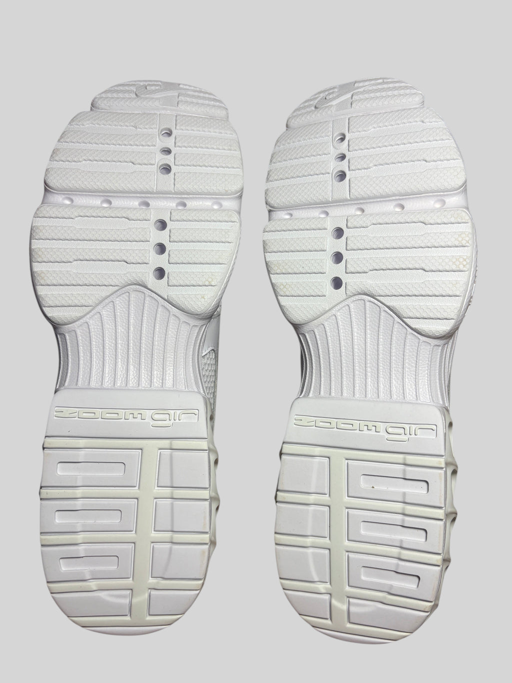 Semelles extérieures blanches des baskets Nike Zoom Air Fire FASHION SC avec motif cranté et amorti Zoom Air visible.