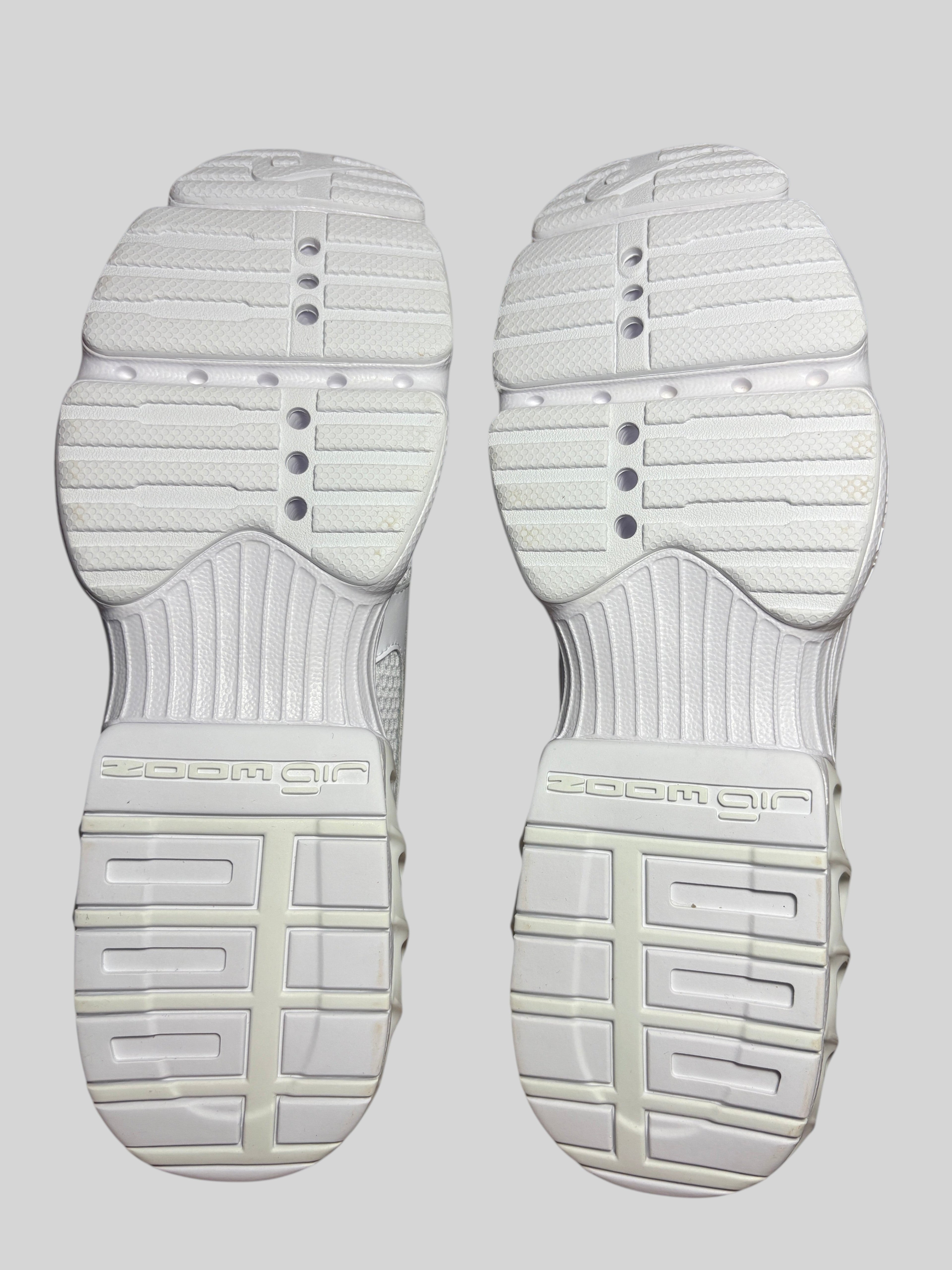 Semelles extérieures blanches des baskets Nike Zoom Air Fire FASHION SC avec motif cranté et amorti Zoom Air visible.