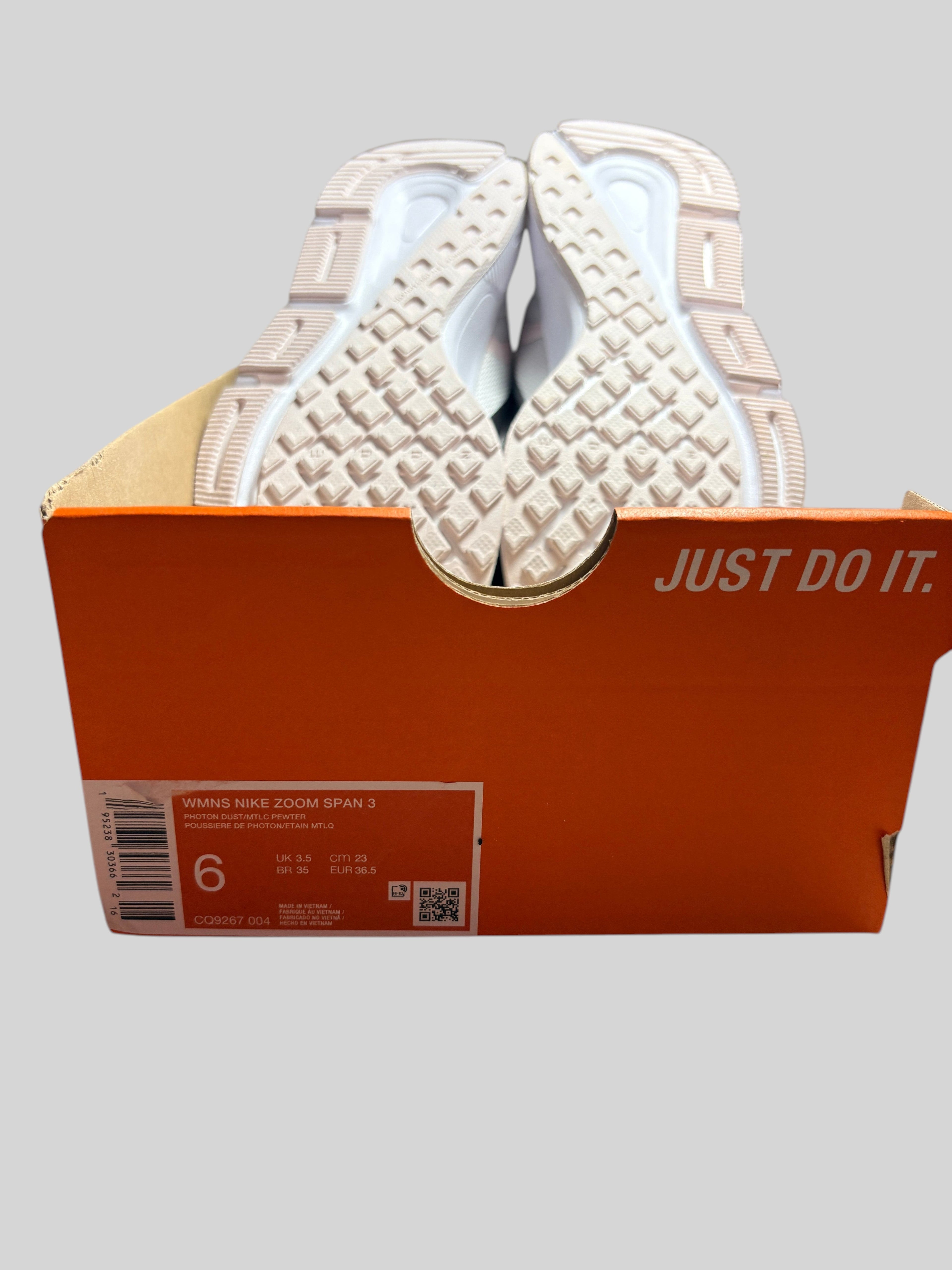 Baskets FASHION SC Nike Zoom Span 3 Photon Dust Grey dans leur boîte orange d'origine, vue sur les semelles.