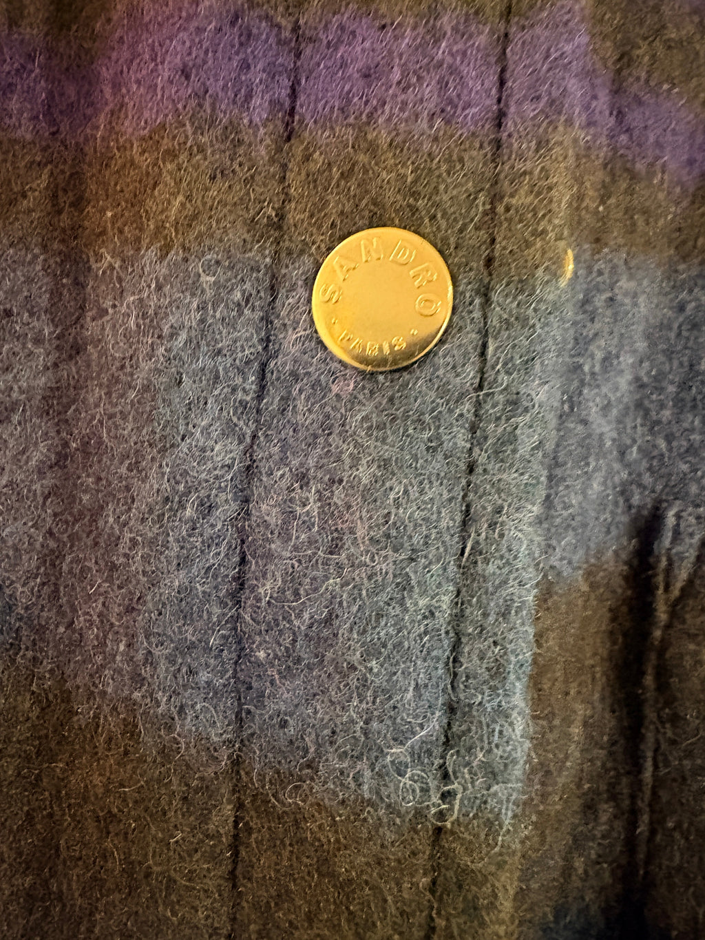 Gros plan sur le bouton-pression doré gravé Sandro du manteau-surchemise en laine à carreaux FASHION SC
