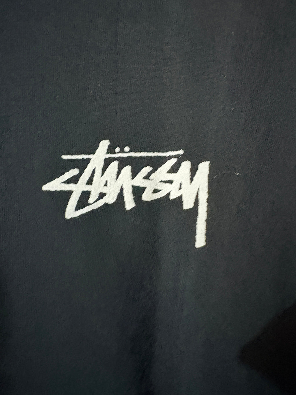 Logo Stüssy blanc imprimé sur la poitrine du t-shirt noir FASHION SC en coton