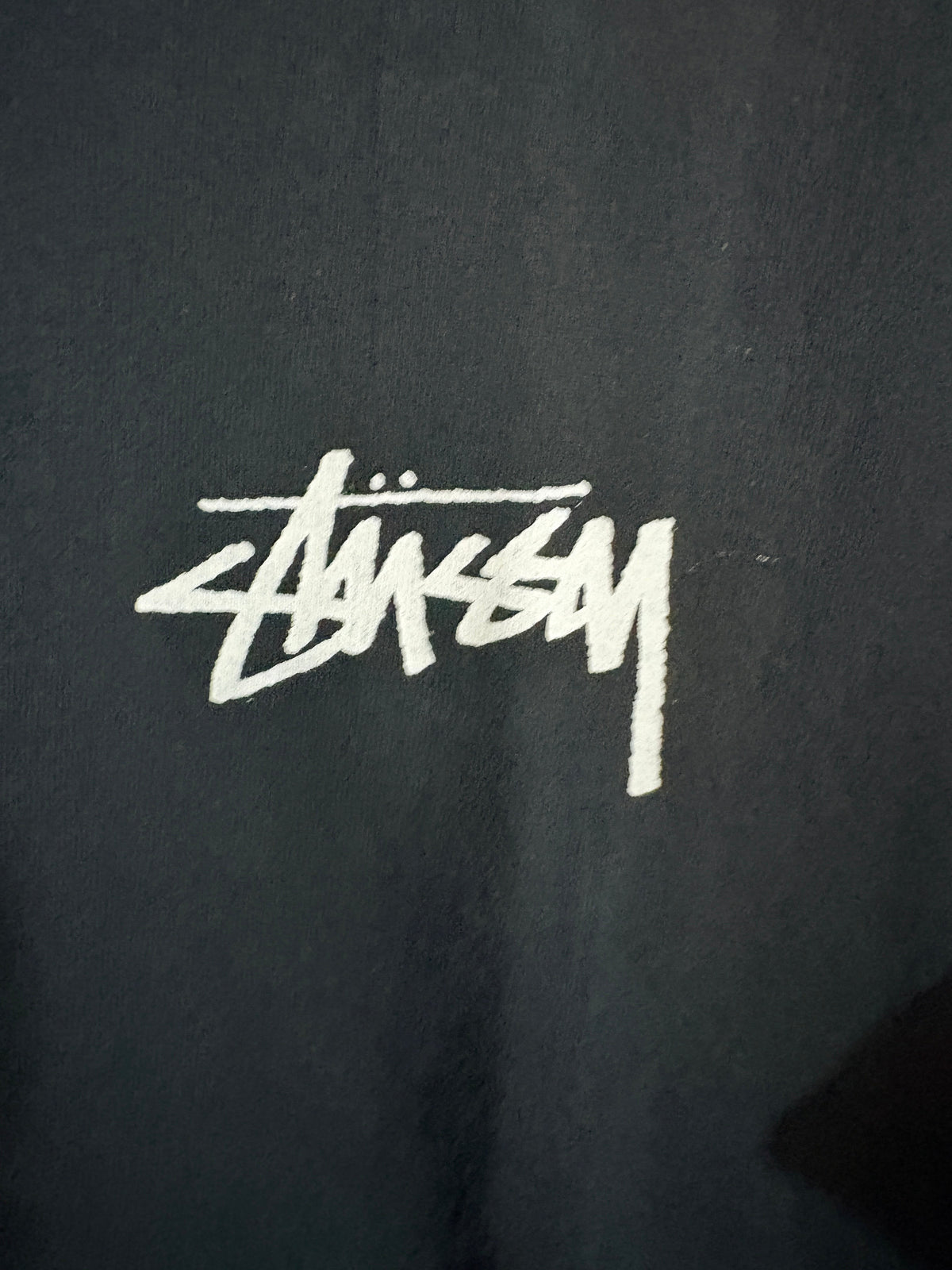 Logo Stüssy blanc imprimé sur la poitrine du t-shirt noir FASHION SC en coton