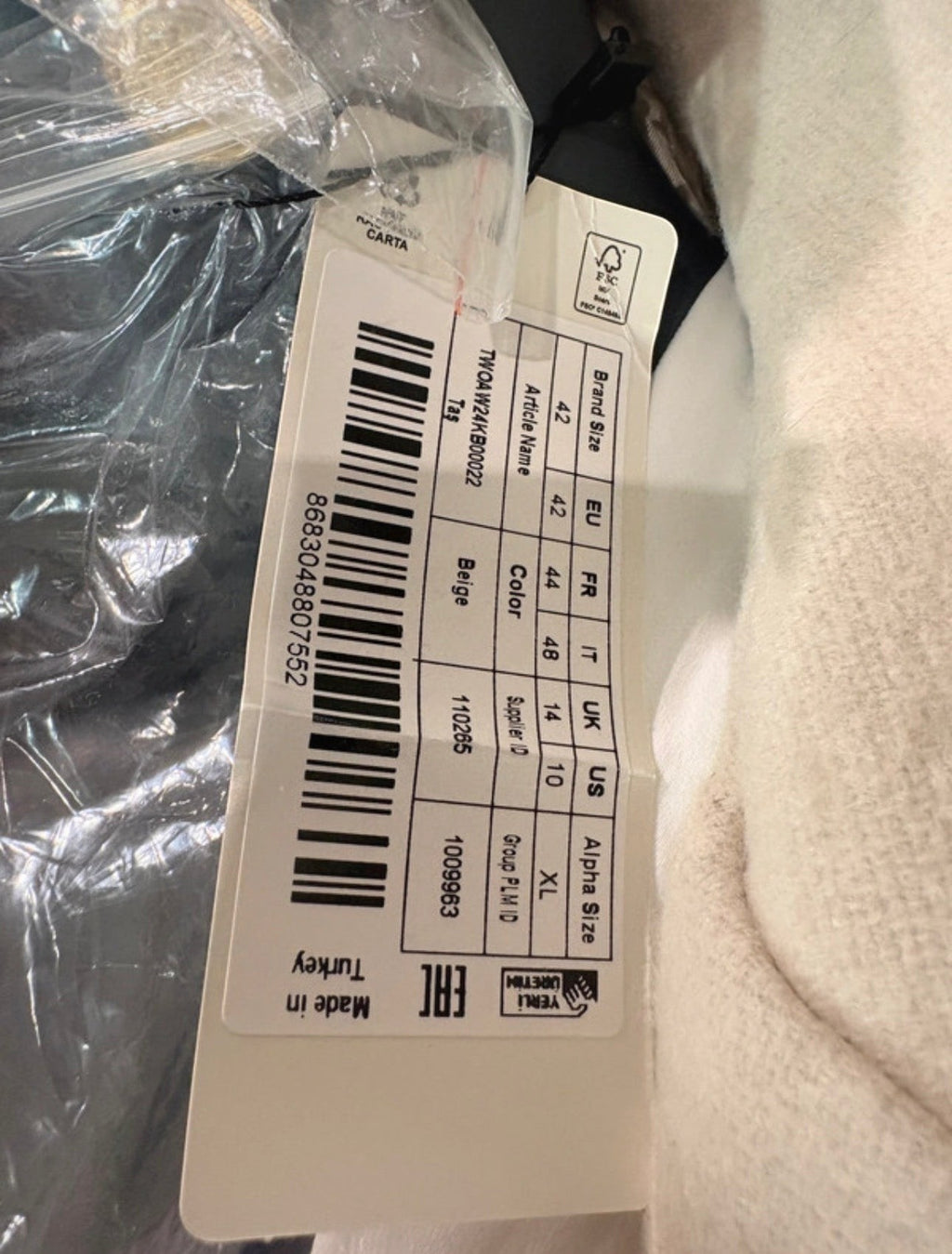 Étiquette de prix et informations de taille sur un manteau FASHION SC Trendyol beige en laine