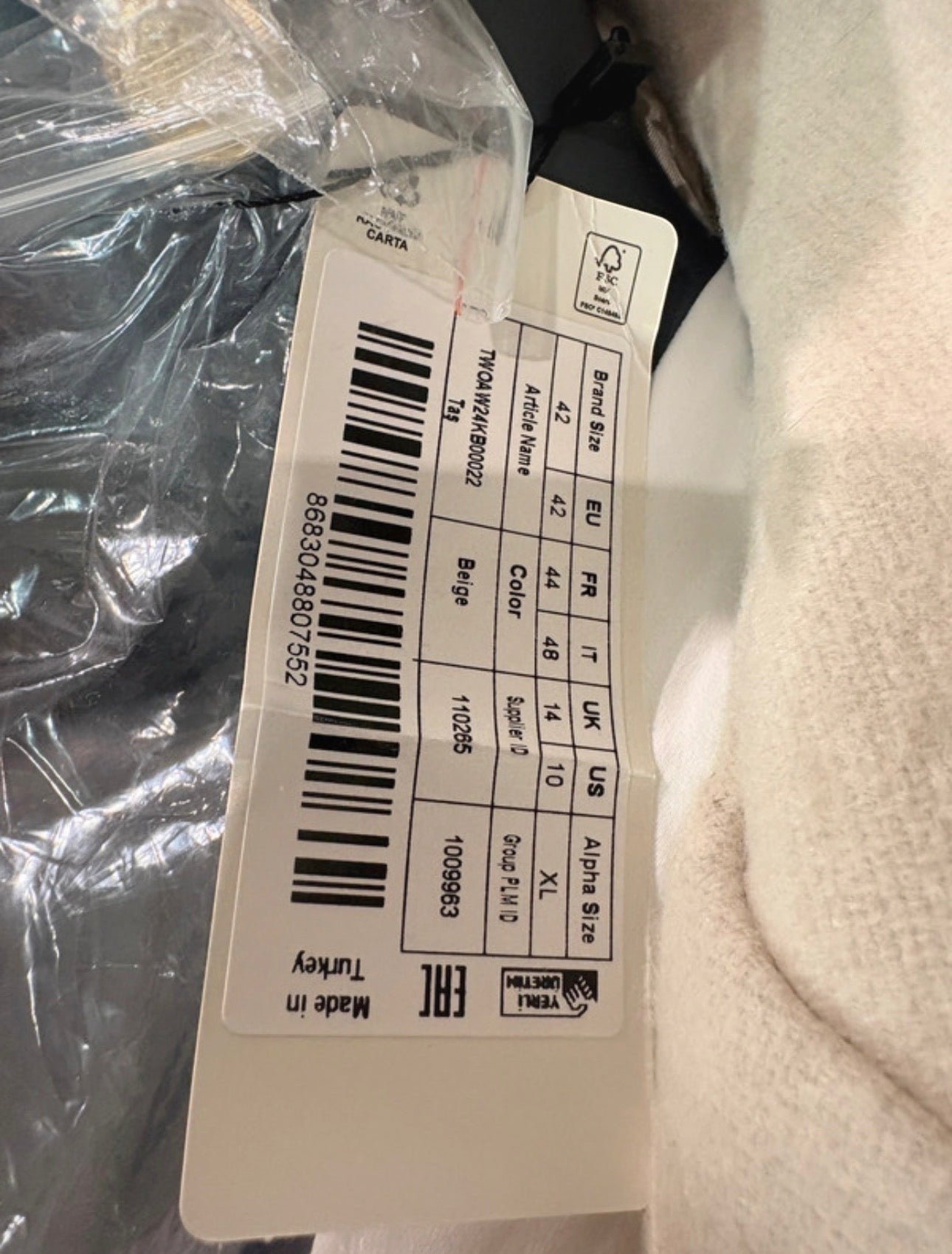 Étiquette de prix et informations de taille sur un manteau FASHION SC Trendyol beige en laine